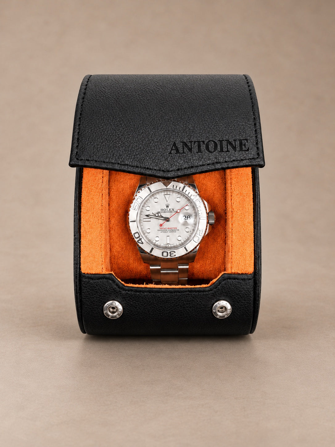 Holborn 1 noir et orange — vue de face avec une montre — personnalisation ANTOINE sur le rabat — fond taupe