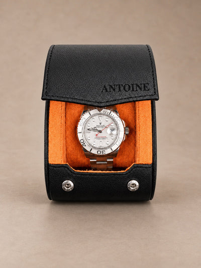Holborn 1 noir et orange — vue de face avec une montre — personnalisation ANTOINE sur le rabat — fond taupe